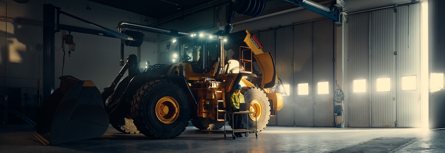 Mujer del equipo de servicio técnico realiza el mantenimiento a una cargadora de ruedas Volvo L220H