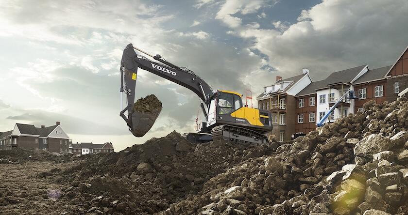 Volvo medium excavator moving dirt on a residential construction site.
